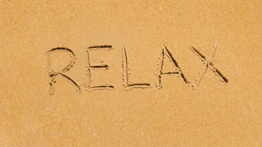 Εικόνα από αμμουδιά που γράφει RELAX στην άμμο