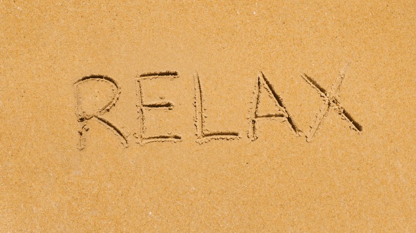 Εικόνα από αμμουδιά που γράφει RELAX στην άμμο